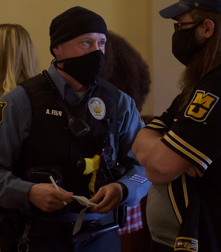 A police officer asks students for their names on Friday